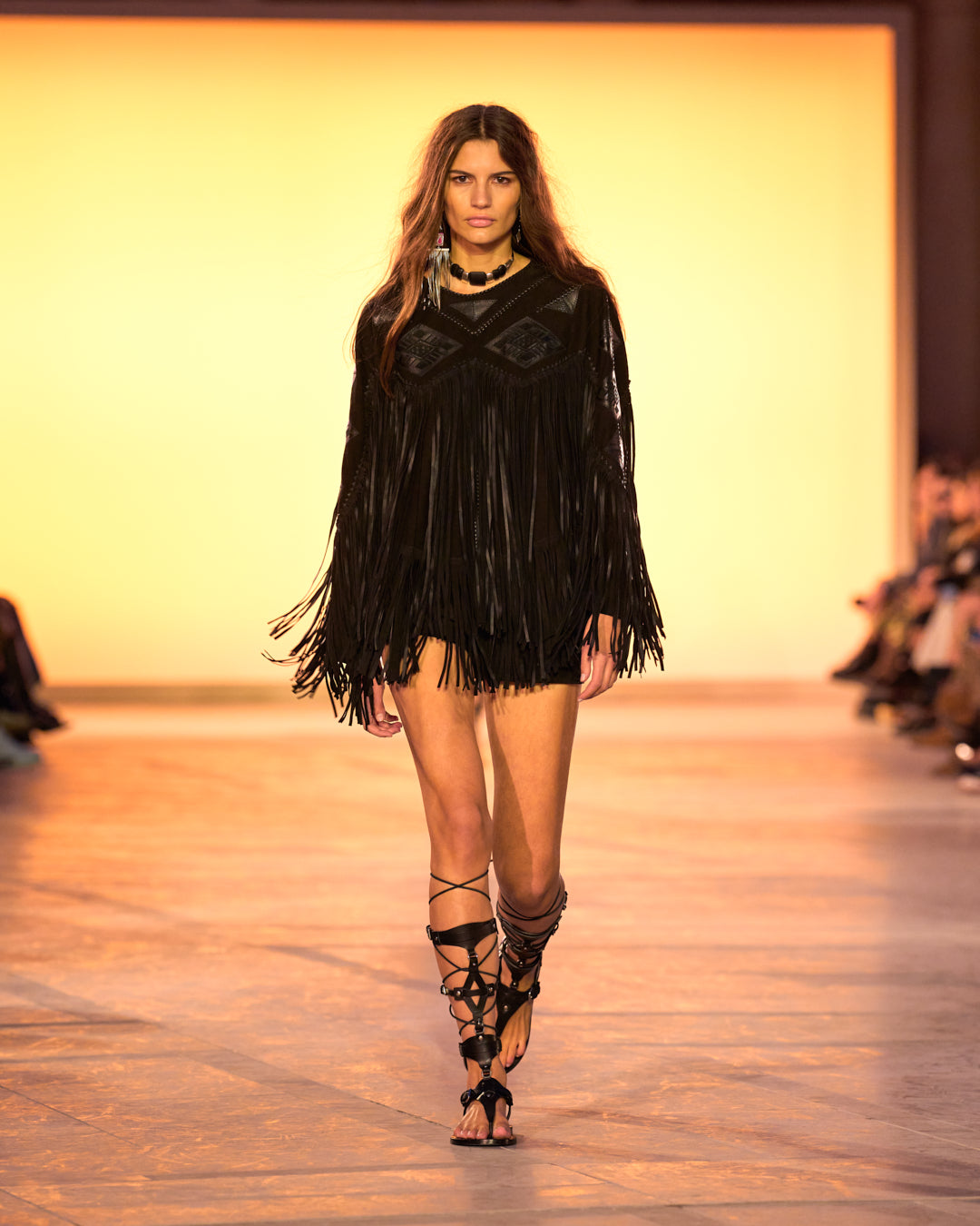 Female model on the catwalk, wearing a Dolci top in suede with black bangs and black sandals.