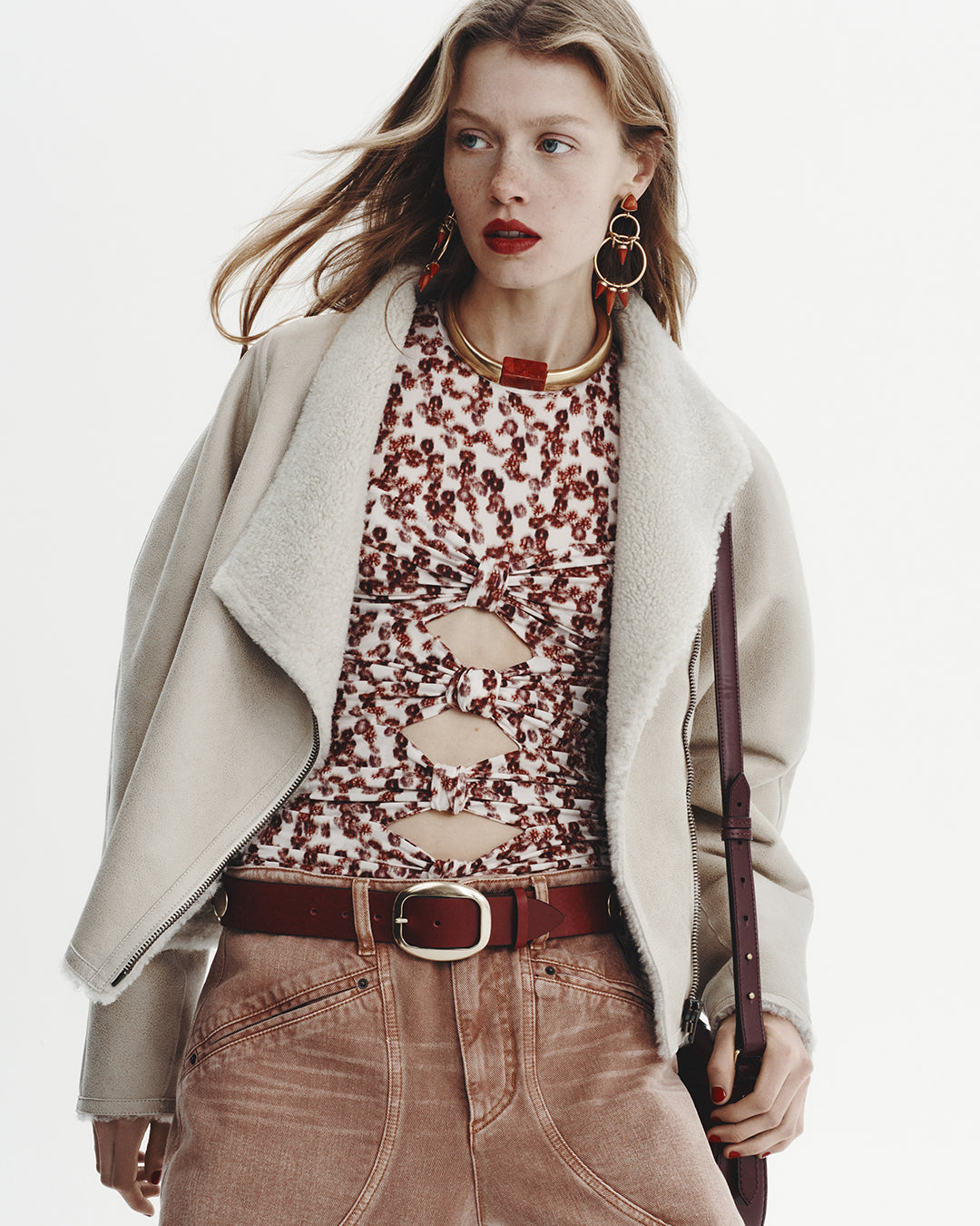 Model wears a shearling jacket with printed top and a denim cargo pants. 