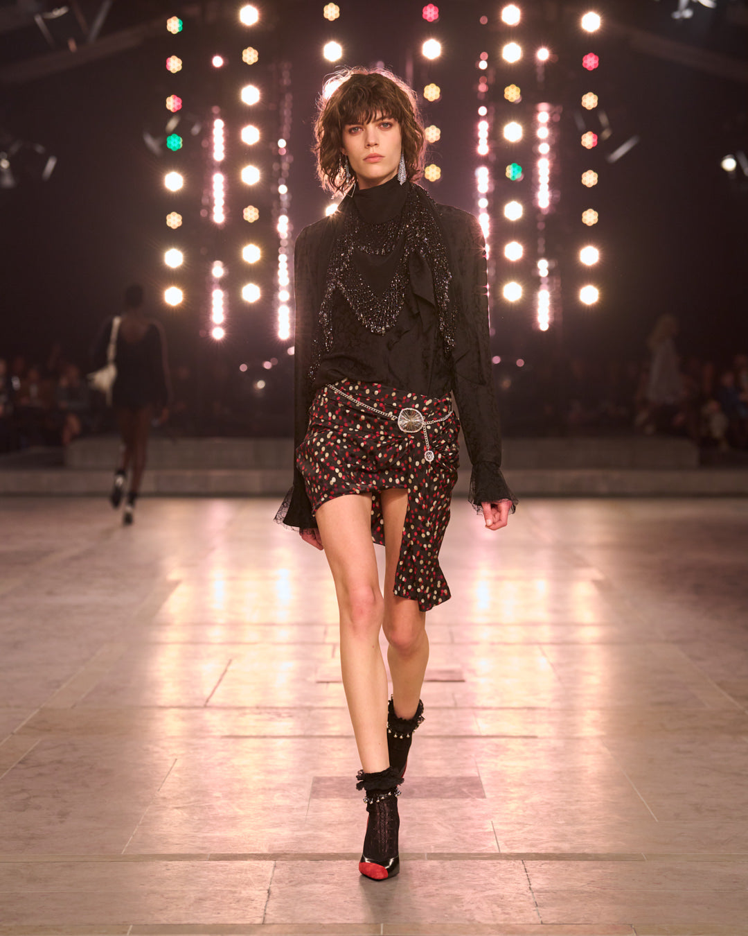Model wears black sweater with mini dots skirt red and black. 